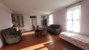 a living room with a table and chairs at Guest House DEDA TINA in Mestia