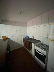 a small kitchen with a stove and a sink at Pouso do caiçara suíte fundo do mar in Paraty