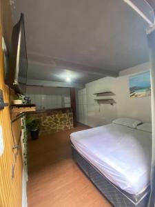 a bedroom with a white bed in a room at Pouso do caiçara suíte fundo do mar in Paraty