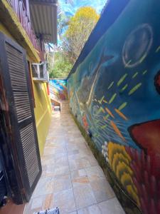 a mural on the side of a wall with fish at Pouso do caiçara suíte fundo do mar in Paraty