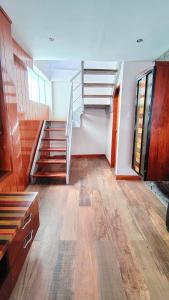 a living room with a staircase and wooden floors at Luxury Duplex Terrace and Grill in Ica