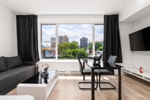 a living room with a table and a large window at Bonjour Plateau Hotel in Montreal