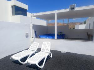 two white chairs sitting on the side of a house at Casa Rinaifi in Guatiza