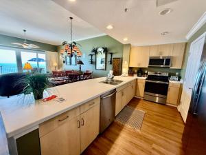 a kitchen with a large counter top and a dining room at Gulf-Front Paradise, Steps to Beach & Pool Access in Panama City Beach