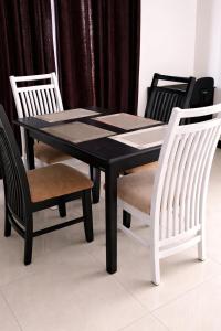 a dining room table with two chairs and a black table and chairs at Nisansala Villa in Matara
