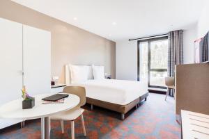 Hotel ParkSaône في ليون: غرفة فندقية بسرير كبير وطاولة