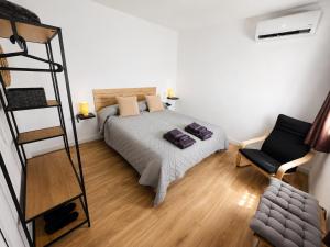 a bedroom with a bed and a ladder and a chair at La casa de curro in Arcos de la Frontera