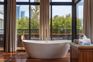a bath tub in a bathroom with a large window at Hotel Parque España in Mexico City