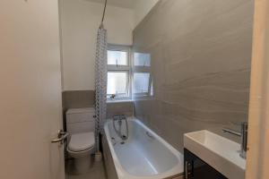 a bathroom with a tub and a toilet and a sink at Clare - Double Room 20 mins walk to centre -Kitchenette Smart TV Shared bathroom in Chesterton +10 photos