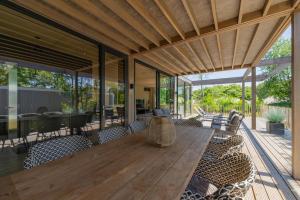 an outdoor dining room with a wooden table and chairs at Forest Villa 6 persons #1212 in Maasbree
