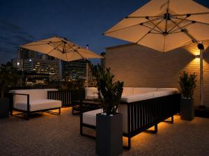 a patio with chairs and umbrellas on a rooftop at At gangnam seoul in Seoul