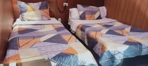 two beds sitting next to each other in a room at Hotel Apartasuite Normandia in Bogotá