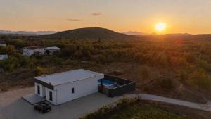 an aerial view of a white house with the sunset in the background at Villa Kleopatra in Međugorje