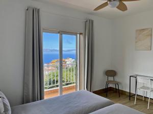 a bedroom with a bed and a view of the ocean at Sea view avocado Finca Ten Days in La Orotava