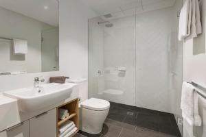 a white bathroom with a sink and a toilet at Quest on Wickham Terrace in Brisbane