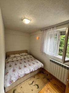 a small bedroom with a bed and a window at Villa JETI in Tetovo