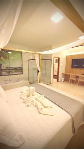 a large white bed in a large room at Hotel & Pousada Recanto do Sabiá in Pirapora