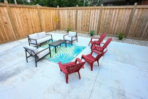 a patio with red chairs and a table and a fence at Benton Motel in Benton