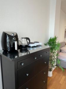 a black dresser with a appliance on top of it at Conscious Stay - Mindful Living in Berlin