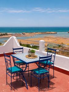 a table and chairs on a balcony with the beach at Le grand château Vue sur Mer uniquement les familles in Oualidia