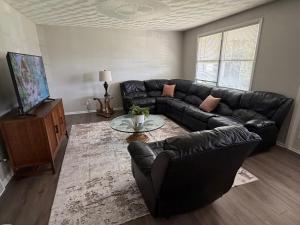 a living room with a black leather couch and a table at The Massillon Retreat! in Massillon