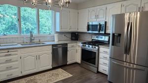 a kitchen with white cabinets and stainless steel appliances at The Massillon Retreat! in Massillon