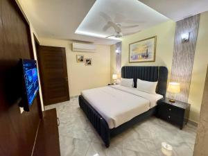 a bedroom with a bed and a flat screen tv at Bella Boutique Hotel Near Centaurus Mall - LMY Hospitality Islamabad in Islamabad