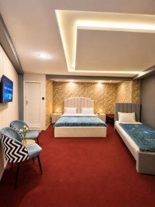 a bedroom with two beds and a red carpet at Mall Rd Murree Ciros Hotel in Murree