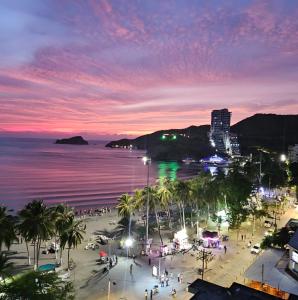 a night view of a beach with palm trees and the ocean at Apartamento 10c Edf.Playa in Santa Marta