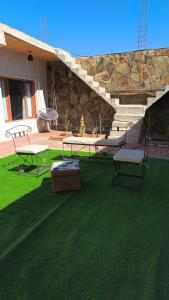a patio with a table and two chairs on the grass at Urku Runa in Humahuaca +4 photos