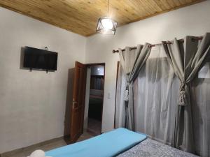 a bedroom with a bed and a tv on the wall at Urku Runa in Humahuaca