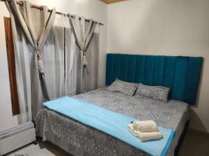 a bed with a blue headboard in a bedroom at Urku Runa in Humahuaca