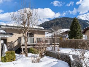 a house with a deck in the snow at IndieBerge in Mittersill