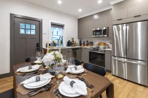 a kitchen with a table with chairs and a stainless steel refrigerator at Cambridge Designer Home Harvard MIT Boston in Cambridge +76 photos