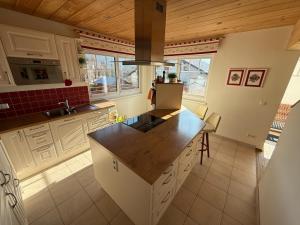 a kitchen with white cabinets and a wooden ceiling at Landhaus Alpenblick Tauplitz in Tauplitz