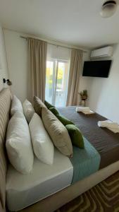 a bed with pillows on it in a bedroom at Apartments Oxygen in Račišće