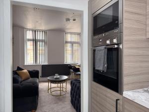 a living room with a couch and a television in a room at Sunderland Central 2BR Apartments in Sunderland