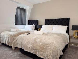 a bedroom with two beds with white pillows at Sunderland Central 2BR Apartments in Sunderland