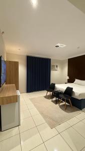 a hotel room with a bed and two chairs at Alassaf 304 in Sīdī Ḩamzah