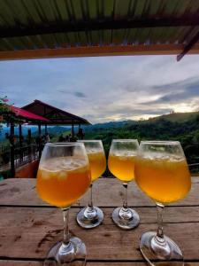three glasses of beer sitting on a wooden table at Alojamiento Las Rocas in Confines