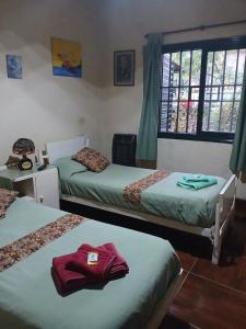 a bedroom with two beds and a red shirt on the bed at Casa amigable dos habitaciones cuatro lugares in Rosario