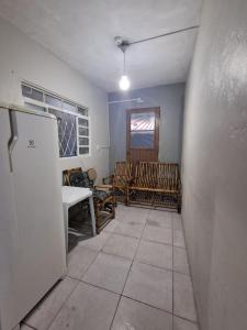 a room with chairs and a table and a refrigerator at Pousada econômica puc in Porto Alegre