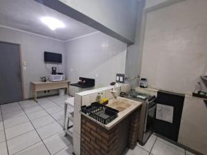 a kitchen with a sink and a stove top oven at Pousada econômica puc in Porto Alegre +14 photos