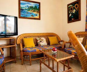 a living room with couches and a tv at Dpto Exclusive Ixtapa in Ixtapa