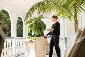 a woman holding a plate of food on a porch at Otahuna Lodge in Christchurch +64 photos