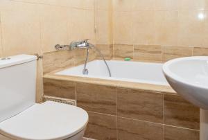 a bathroom with a toilet and a tub and a sink at MAAT Luxury Homes in Accra +33 photos