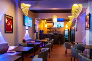 a restaurant with tables and chairs and a bar at MAAT Luxury Homes in Accra
