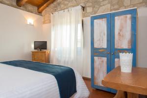 1 dormitorio con 1 cama y puerta azul en Valle Dell'Aquila Country House, en Settefrati