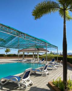 a group of lounge chairs next to a swimming pool at RKJ condotel 2BR in Cupang