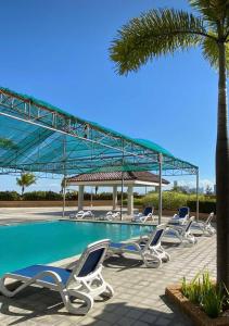 a row of lounge chairs next to a swimming pool at RKJ condotel 2BR in Cupang